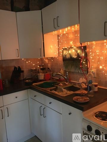 Ypsilanti apartment for rent - A kitchen with white cabinets and a black countertop.
