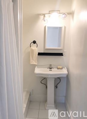 Ypsilanti apartment for rent - A bathroom with a towel hanging on the wall and a mirror above the sink.
