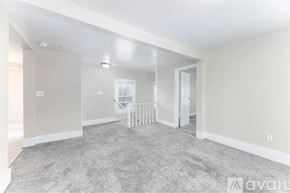 Ypsilanti apartment for rent - A spacious room with a carpeted floor and a white door.