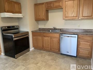 Bremerton house for rent - A kitchen with wooden cabinets and a black oven.