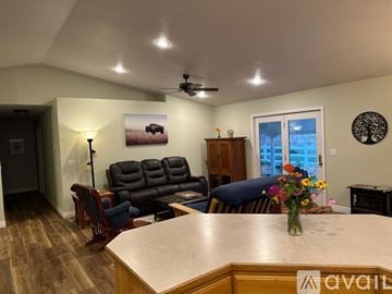 Weiser house for rent - A living room with a couch, chairs, and a painting of a bison on the wall.