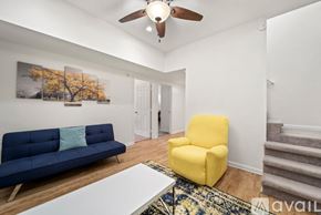 Winston-Salem apartment for rent - A living room with a blue couch, yellow chair, and a white coffee table.