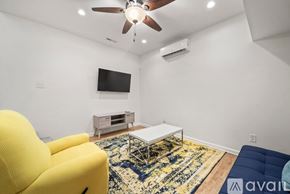 Winston-Salem apartment for rent - A living room with a yellow chair, a white coffee table, and a blue couch.