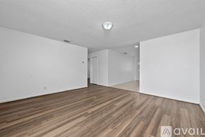 Kissimmee townhouse for rent - A spacious room with wooden flooring and white walls.