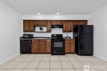 Kissimmee townhouse for rent - A kitchen with black appliances and wooden cabinets.