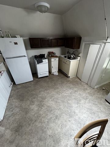 Ypsilanti apartment for rent - A small kitchen with a white refrigerator, white stove, and white cabinets.