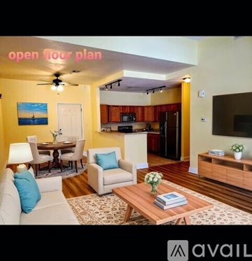 Perth Amboy apartment for rent - A living room with a dining table and chairs, a sofa, a coffee table, and a painting on the wall.