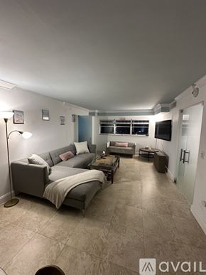 Miami Beach apartment for rent - A living room with a glass table and chairs, a couch, and a television.