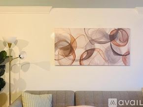 Miami Beach apartment for rent - A modern living room with a grey sofa, a round mirror, and a wooden coffee table.