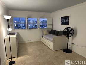 Miami Beach apartment for rent - A modern kitchen with a glass table and bar stools.