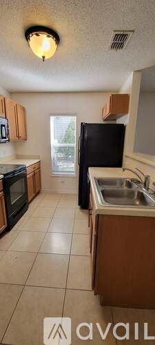 Kissimmee house for rent - A kitchen with wooden cabinets and black appliances.