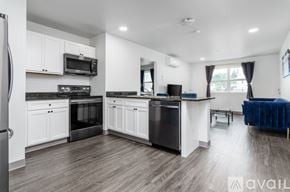 Johnson City apartment for rent - A modern kitchen with white cabinets and black appliances.