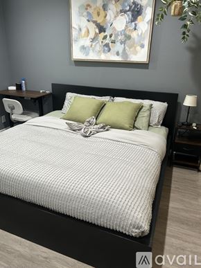 Signal Hill condo for rent - A modern bedroom with a large bed and a small nightstand.