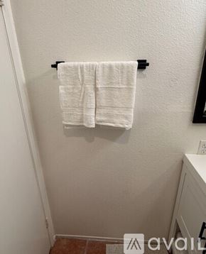 Signal Hill condo for rent - A sunny day at the entrance of a house with a gate and a palm tree.