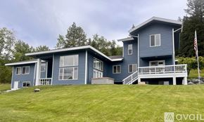 Bigfork house for rent - A blue house with a flag on the right side.