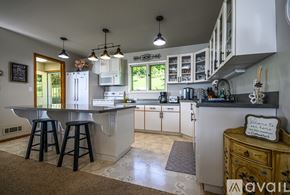 Bigfork house for rent - A kitchen with a table and bar stools.