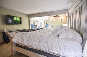 Bigfork house for rent - A bedroom with a large bed and a flat screen TV mounted on the wall.