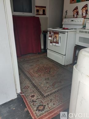 New Orleans apartment for rent - A kitchen with a red curtain and a rug on the floor.