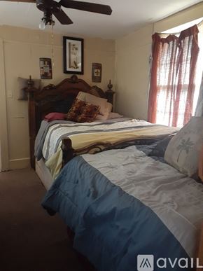 New Orleans apartment for rent - A bedroom with a bed, pillows, and a ceiling fan.