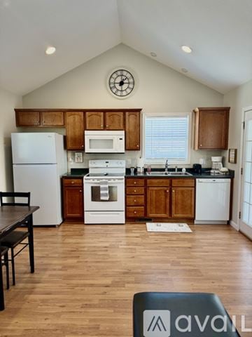 Marion house for rent - A kitchen with wooden cabinets and a white fridge.