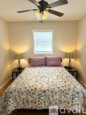 Marion house for rent - A bedroom with a floral bedspread and two lamps on either side of the bed.