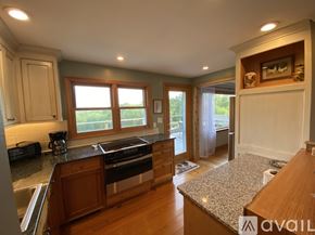 West Morris house for rent - A kitchen with wooden cabinets and a granite countertop.