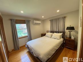 West Morris house for rent - A bedroom with a large bed and wooden floors.