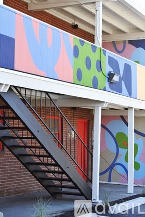 Denver apartment for rent - A staircase with a metal railing is in front of a colorful mural.