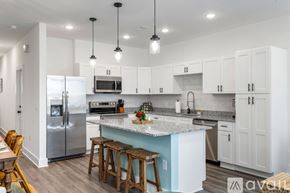 North Charleston townhouse for rent - A kitchen with white cabinets and a blue island.