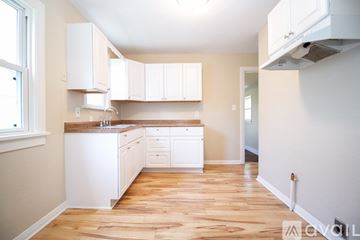 Toledo house for rent - A kitchen with white cabinets and wooden floors.