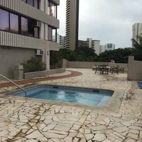 Honolulu condo for rent - A pool surrounded by a stone patio.
