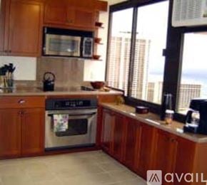 Honolulu condo for rent - A kitchen with wooden cabinets and a stainless steel oven.