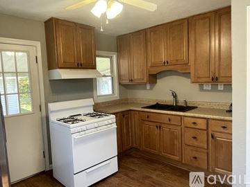 Dayton house for rent - A kitchen with a white stove and wooden cabinets.