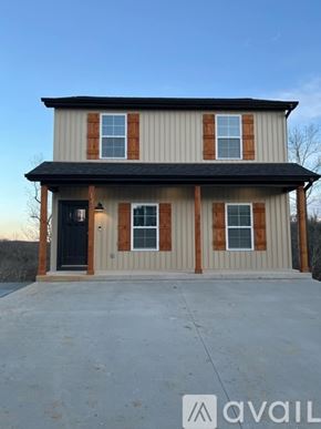 Waynesville apartment for rent - A two-story house with a black door and windows with brown trim.