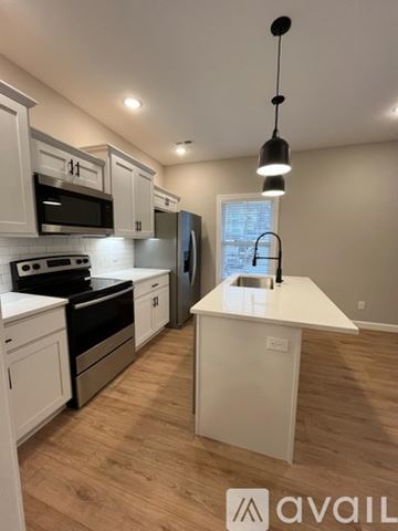 Waynesville apartment for rent - A kitchen with white cabinets and a wooden island.