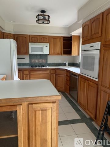 Lakewood house for rent - A kitchen with wooden cabinets and a white counter.