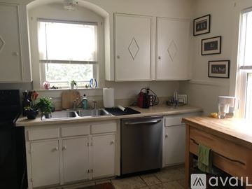Charleston house for rent - A kitchen with white cabinets and a window above the sink.
