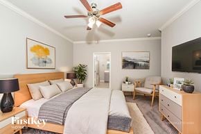 Helena house for rent - A bedroom with a bed, a chair, a dresser, and a ceiling fan.