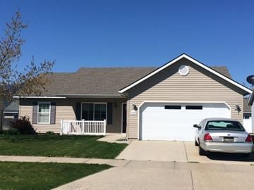 Rathdrum house for rent - A silver car is parked in front of a garage.