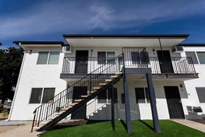 Lakeside apartment for rent - A white two-story house with a black metal staircase.