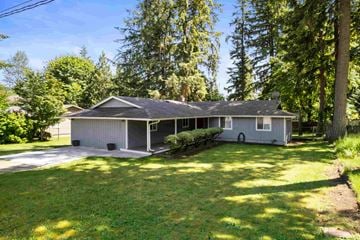 Renton house for rent - A house with a grey roof and a grey garage door is surrounded by trees.