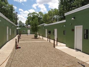 Flagstaff apartment for rent - A courtyard surrounded by green buildings with white doors.