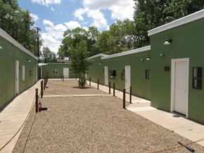 Flagstaff apartment for rent - A courtyard surrounded by green buildings with white doors.