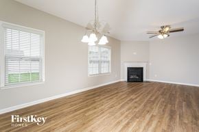 Jamestown house for rent - A spacious room with wood flooring and a fireplace.