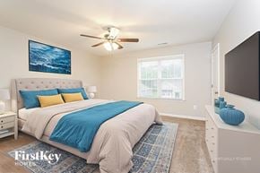 Jamestown house for rent - A bedroom with a large bed and a ceiling fan.