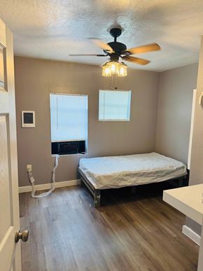 Houston apartment for rent - A bedroom with a bed, a window, and a ceiling fan.