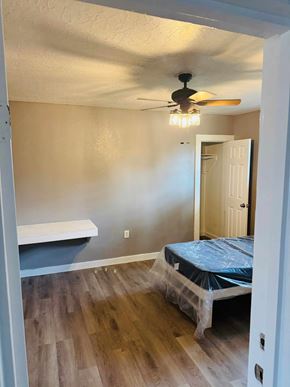 Houston apartment for rent - A room with a ceiling fan and a bed covered in plastic.