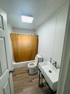 Houston apartment for rent - A bathroom with a toilet, sink, and shower curtain.