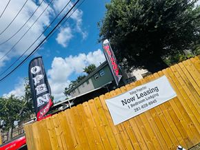 Houston apartment for rent - A sign for a bed and breakfast leasing service is displayed on a wooden fence.