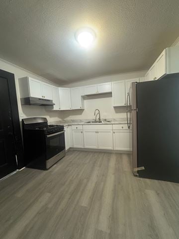 Louisville house for rent - A kitchen with black appliances and white cabinets.